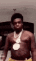 a shirtless man is wearing a medal around his neck .