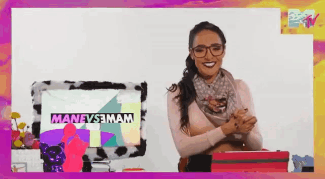 a woman wearing glasses stands in front of a screen that says manevsemam