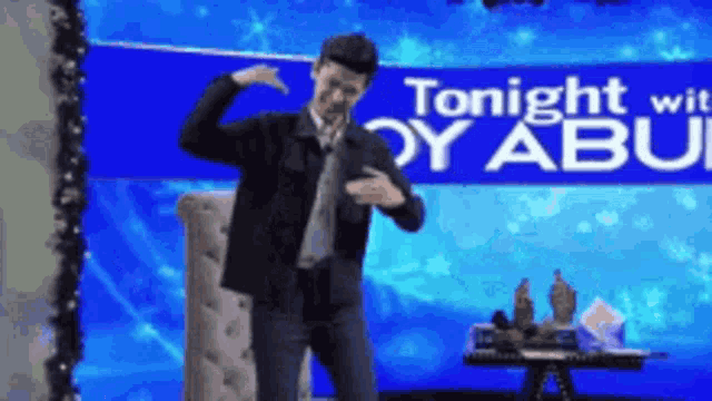 a man is dancing in front of a sign that says " tonight wit boy abu "