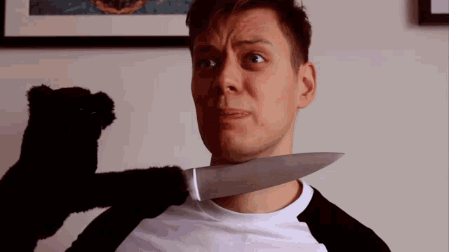 a man with a knife in his neck is being held by a stuffed animal
