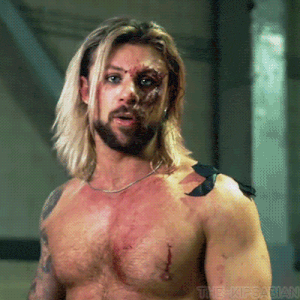 a man with long blonde hair and a beard has a tattoo on his shoulder