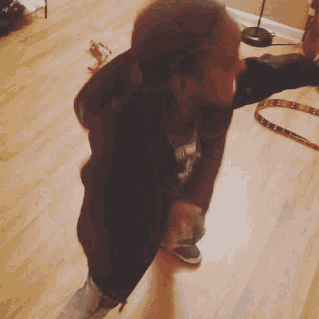 a blurry picture of a person standing on a wooden floor with a snake in the background