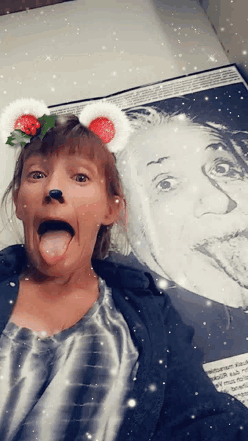 a woman making a funny face in front of a albert einstein portrait