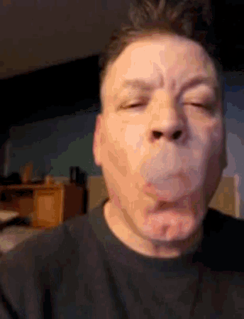 a man blowing a bubble with his mouth open
