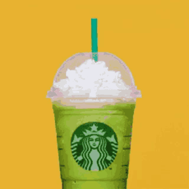 a starbucks cup with whipped cream and a green straw