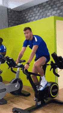 a man riding an exercise bike in a gym