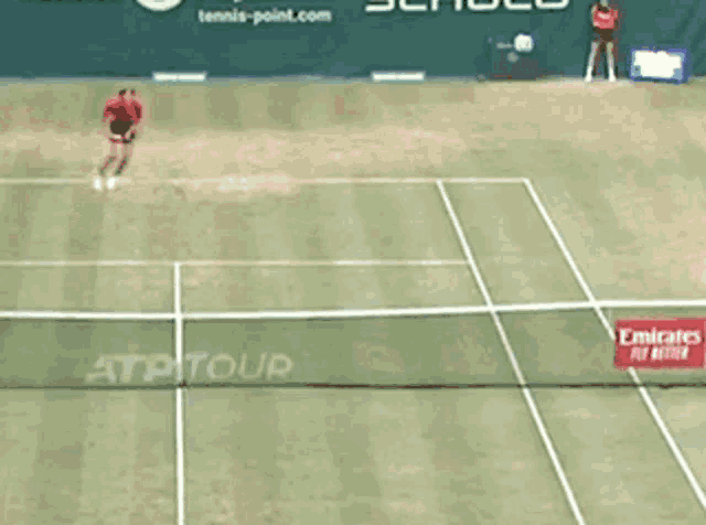 a tennis court with a emirates fly better banner on the net