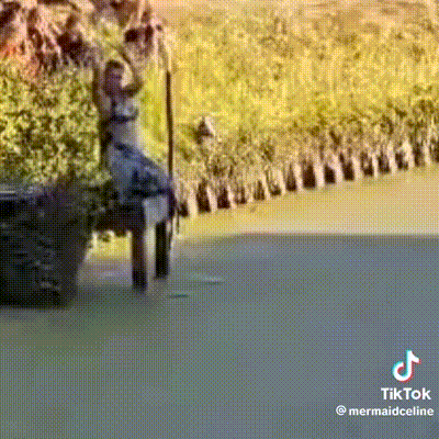 a person is sitting on a bench in the water and holding onto a pole .
