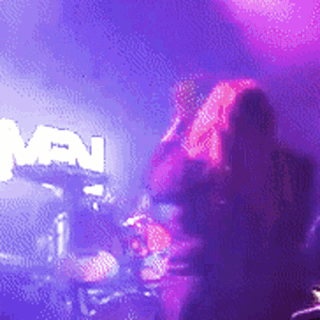 a blurry photo of a man playing drums in front of a sign that says ' men '