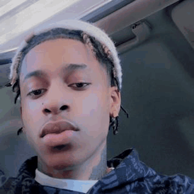 a young man is taking a selfie in a car .