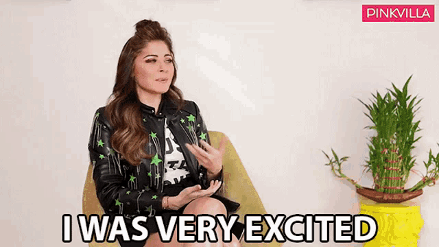 a woman in a leather jacket is sitting in a chair and saying i was very excited .