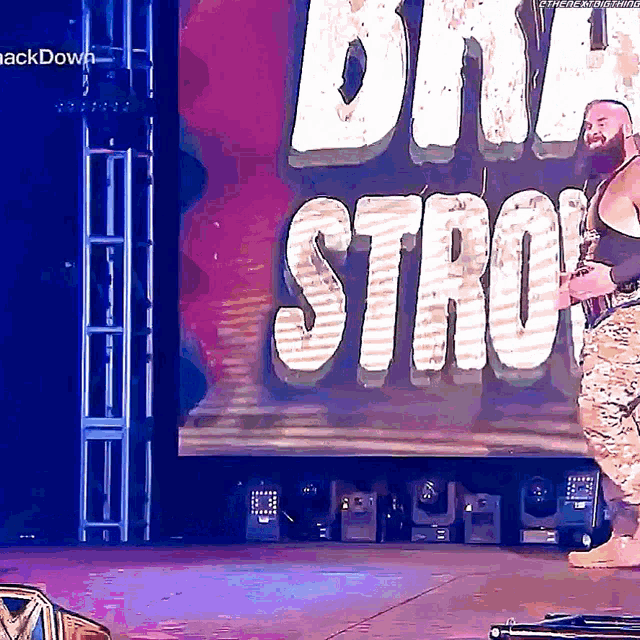 a wrestler stands on a stage in front of a sign that says day strow
