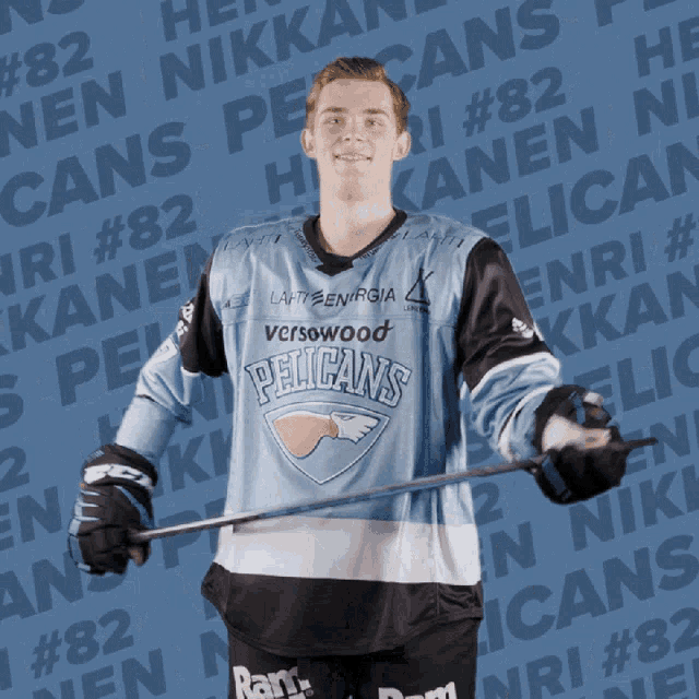 a pelican 's hockey player holds a stick in front of a blue background