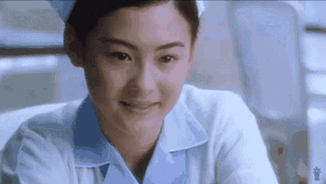 a close up of a nurse smiling in a hospital .