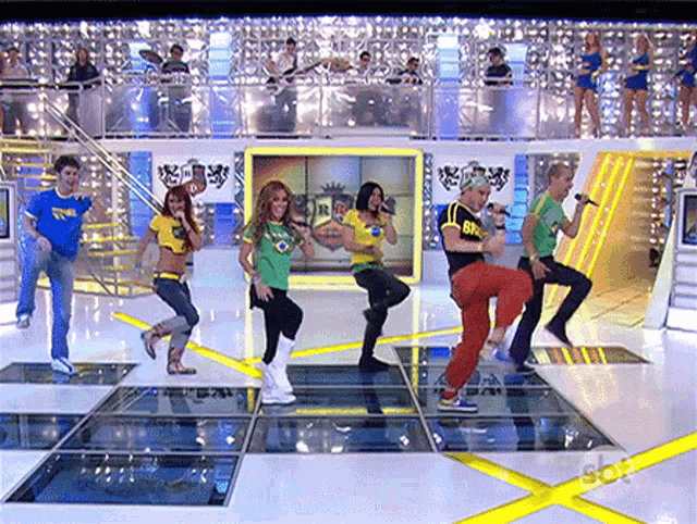 a group of people are dancing on a stage with a sign that says sbt