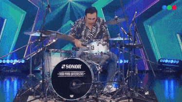 a man is playing a sonor drum set on stage