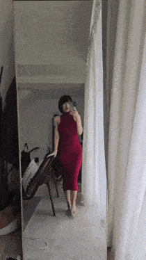 a woman in a red dress taking a selfie in front of a mirror