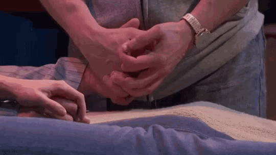 a man and woman are holding hands while laying on a bed .