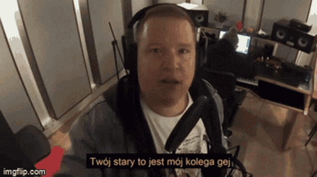 a man wearing headphones says twoj stary to jest moj kolega gej in front of a microphone