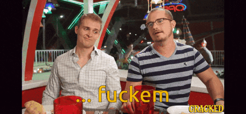 two men are sitting at a table with the words fuckem cracked in yellow letters