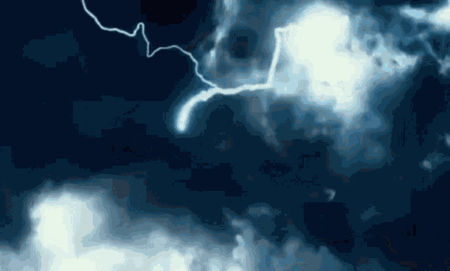 a lightning bolt is flying through a cloudy sky at night .