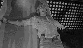 a man is laying on the floor with his arms outstretched and his shirt off .