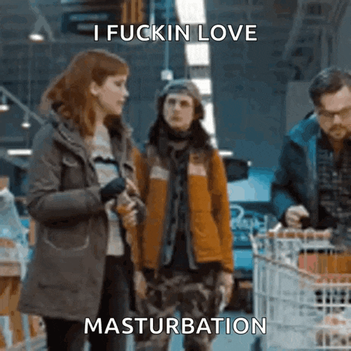a man is pushing a shopping cart in a supermarket while a woman stands next to him .
