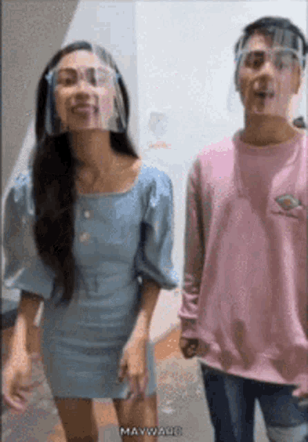 a man and a woman wearing face shields
