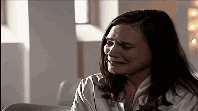 a woman is crying while wearing a white coat
