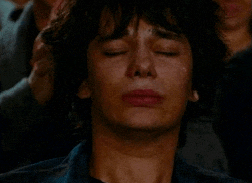 a close up of a man 's face with a tear running down his cheek