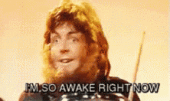 a man with a beard is holding a sword and saying i 'm so awake right now .