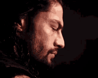 a close up of a man 's face with a beard and dreadlocks .