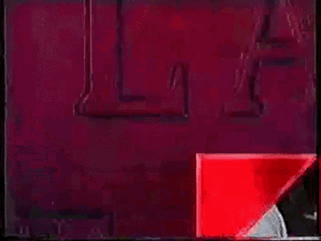 a woman in a white shirt is standing in front of a red triangle .