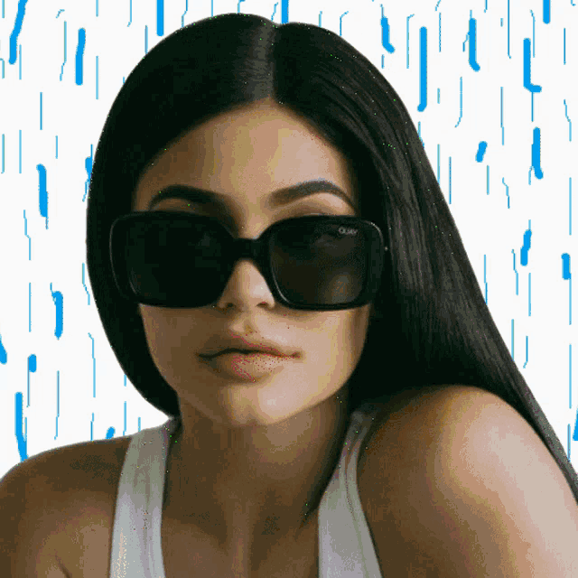 a woman wearing sunglasses that say quay on the lenses