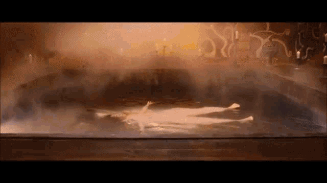 a woman is laying in a bathtub filled with steam .