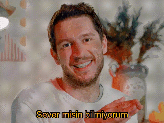 a man with a beard is smiling with the words sever misin bilmiyorum written below him