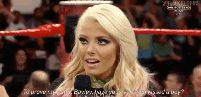 a woman in a wrestling ring is talking into a microphone and asking to prove her point .