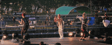a group of people on a stage with the letters d on the bottom