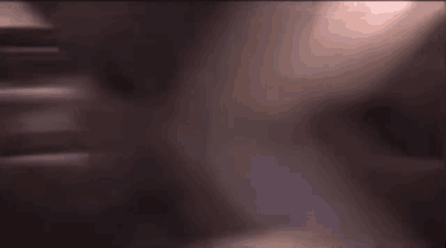 a blurred image of a dark room with a light shining through the ceiling .