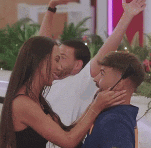 a woman is touching a man 's face while a man holds his arm in the air .