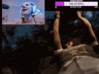 a woman wearing headphones is hanging upside down in front of a screen that says ' 106 21.20% '