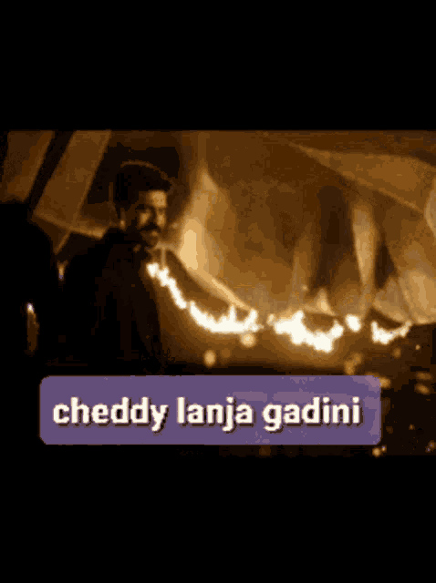 a man in a suit is standing in front of a burning building with a purple sticker that says cheddy lanja gadini