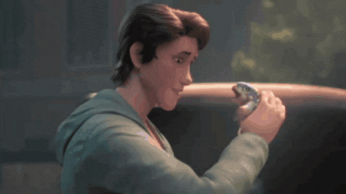 a man in a green hoodie holds a snake in his hand