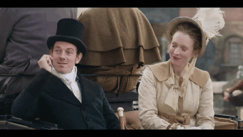 a man in a top hat is sitting next to a woman in a hat