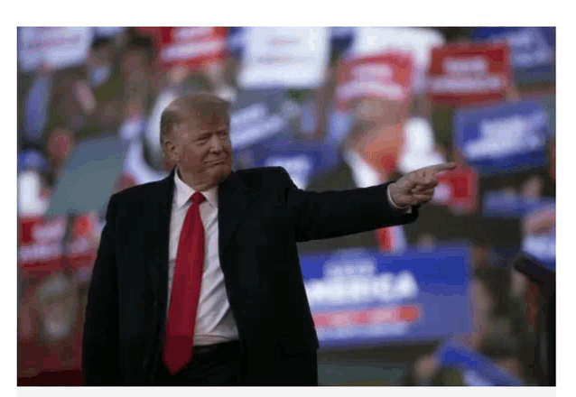 a man in a suit and tie is pointing his finger