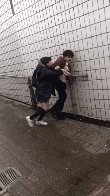 a man in a blue jacket is carrying a girl on his shoulders
