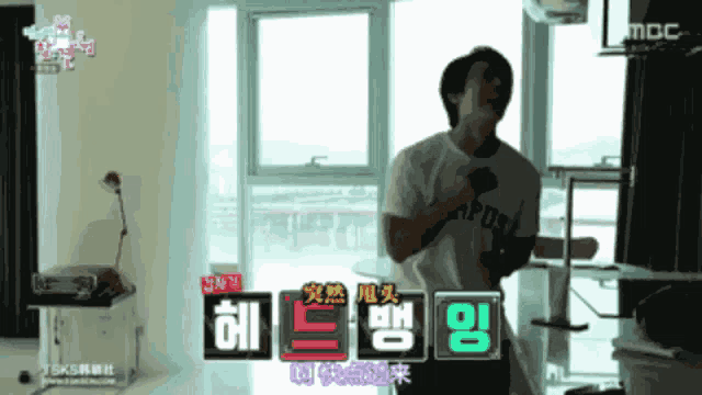 a man is singing into a microphone in a room that says mbc on the bottom