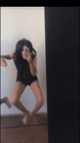 a woman is taking a picture of herself in the mirror