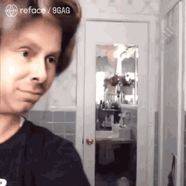 a man is taking a selfie in a bathroom with a mirror .