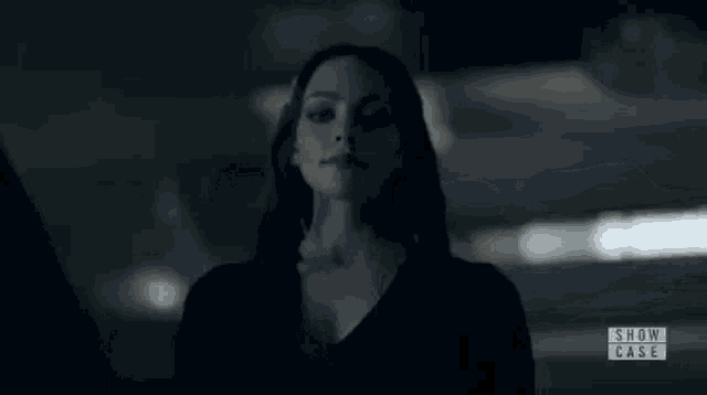 a close up of a woman 's face in a dark room looking at the camera .